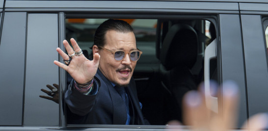 El actor Johnny Depp saluda a sus simpatizantes al salir de la corte del condado de Fairfax durante su muy difundido juicio por difamación contra su exesposa Amber Heard, el 27 de mayo de 2022 en Fairfax, Virginia. (Foto AP/Craig Hudson, archivo)