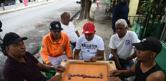 Vecinos de un barrio popular de Santo Domingo jugando una partida de dominó. / Jorge martínez