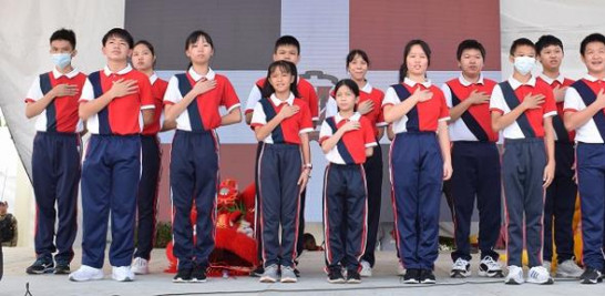 Jovenes de la escuela dominico china entonan las notas de los himnos nacionales de ambos paises.