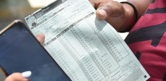 Un ciudadano muestra las multas que le aparecen.
