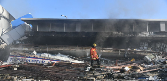 Bombero entre los escombros de la tienda de aires acondicionados. Jorge Martínez / LD