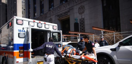 Una mujer recibe asistencia médica después de caer fuera del juzgado penal de Manhattan el 3 de abril de 2023 en la ciudad de Nueva York. Foto: Kena Betancur/Getty Images/AFP