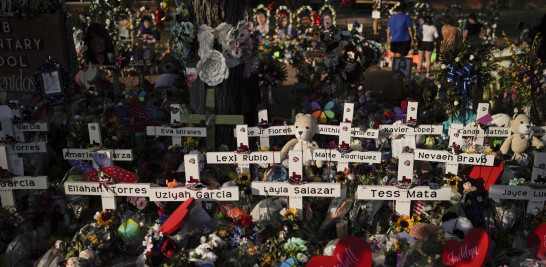 Flores apiladas alrededor de cruces con los nombres de las víctimas asesinadas en un tiroteo a mansalva en la escuela primaria Robb, como parte de un monumento improvisado frente a esa escuela en Uvalde, Texas, el 31 de mayo de 2022.