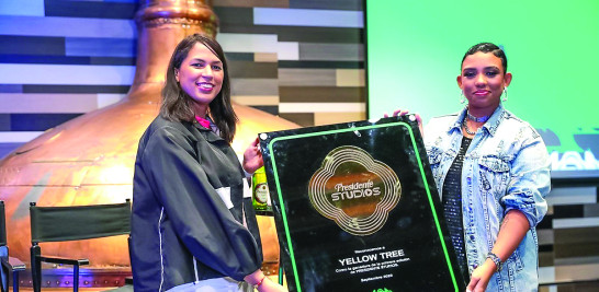 Noelia Merejo, ejecutiva de Cervecería Nacional Dominicana, le entrega la placa de ganadora de “Presidente Studios” a Yellow Tree.país.