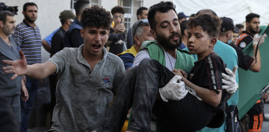 Un hombre lleva a un niño herido al hospital de al-Shifa