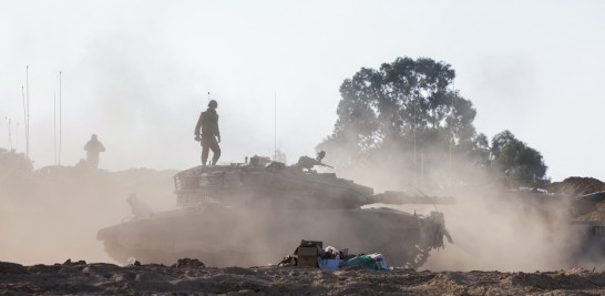 Soldados de la unidad de tanques israelíes se sitúan sobre sus vehículos blindados situados a lo largo de la frontera con Gaza.