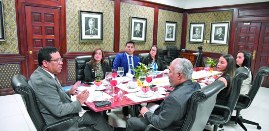 El director de Compras y Contrataciones Públicas, Carlos Pimentel, conversa con el subdirector del Listín Diario, Fabio Cabral, acompañado de otros funcionarios de la entidad.