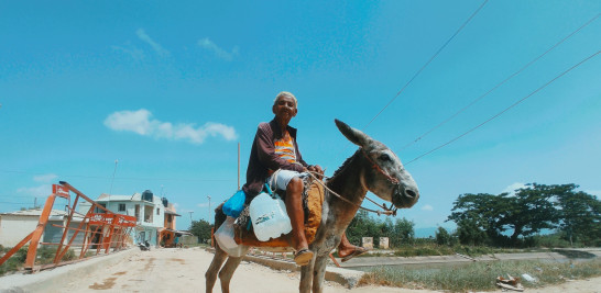 Montada en un burro, la señora Ángela Guaba, de aproximadamente 70 años, para subsistir recorre cada mañana varios sectores del distrito municipal de Cienfuegos de la provincia Santiago, para revender leche.