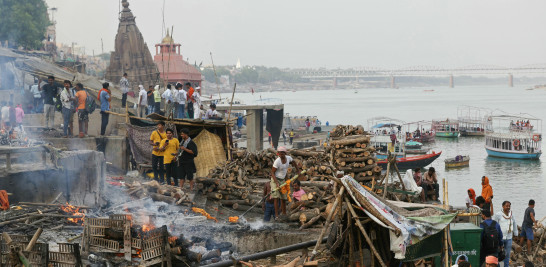 En esta fotografía tomada el 16 de junio de 2024, un cremador (C) de la comunidad Dom limpia una pira después de los ritos funerarios, en Manikarnika Ghat, a lo largo de las orillas del río Ganges en Varanasi.