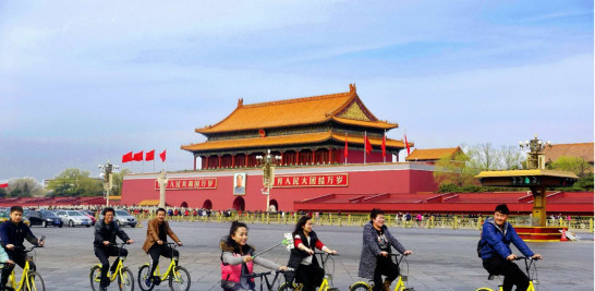 Ciudadanos chinos pasean en bicicletas en la plaza Tiananmen