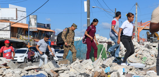 Comerciantes caminando sobre los escombros