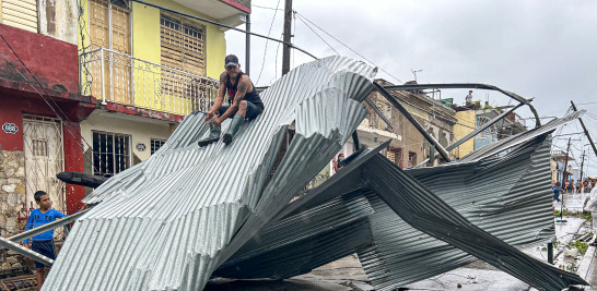 Un residente se sienta en parte del techo de su casa, dañada por el huracán Melissa, en Santiago de Cuba, el 29 de octubre de 2025.