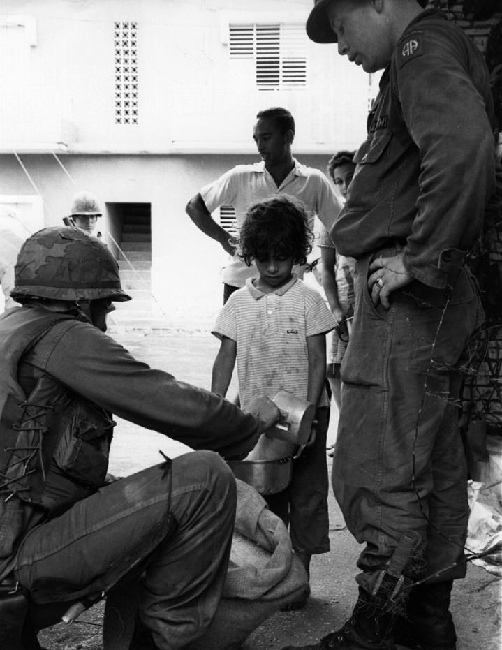 Dos soldados estadounidenses distribuyen arroz a los habitantes de Santo Domingo.