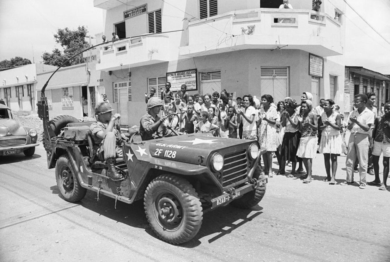 Grupo de dominicanos aplaude y grita “Go Home Yankee” a un par de tropas estadounidenses en. Santo Domingo.