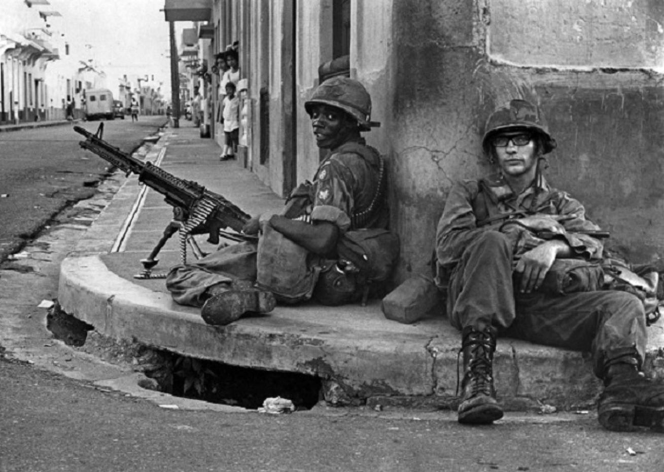 Soldados de una fuerza interamericana custodian esquina en el ex sector rebelde de Santo Domingo 25 de octubre de 1965