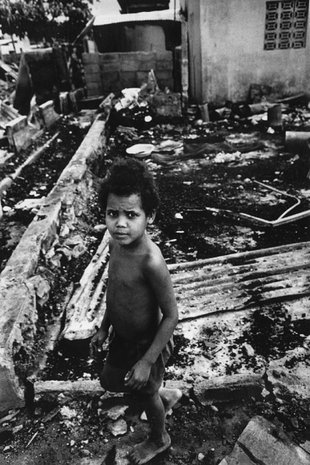 Un niño se encuentra entre las ruinas de una casa bombardeada en la ciudad de Santo Domingo durante la guerra civil dominicana.