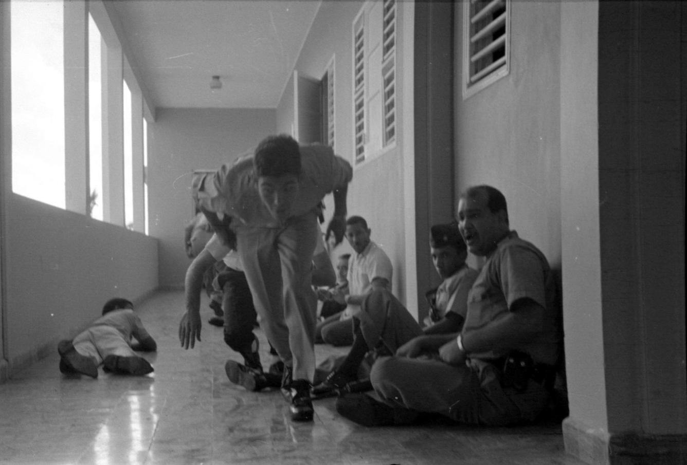 Imagen en la que se observa a Francisco Alberto Caamaño Deñó y otros compañeros  atrincherados durante el asalto al Hotel Matum en Santiago el 19 de diciembre de 1965.