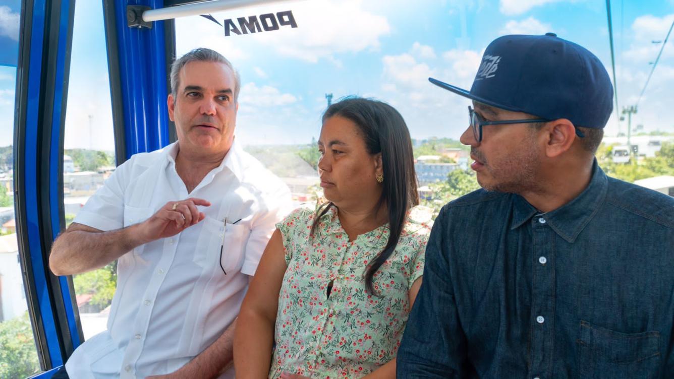 El presidente Luis Abinader mientras conversaba con dos personas en la telecabina del Teleférico Los Alcarrizos.