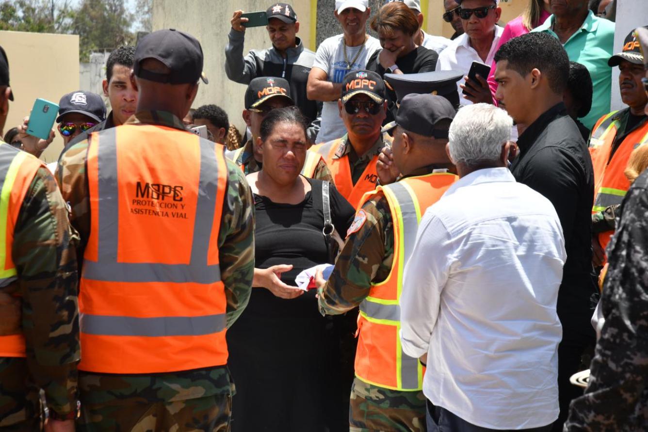Representantes del Ministerio de Obras Públicas y Comunicaciones hacen entrega de la Bander Nacional a hermana del fenecido.