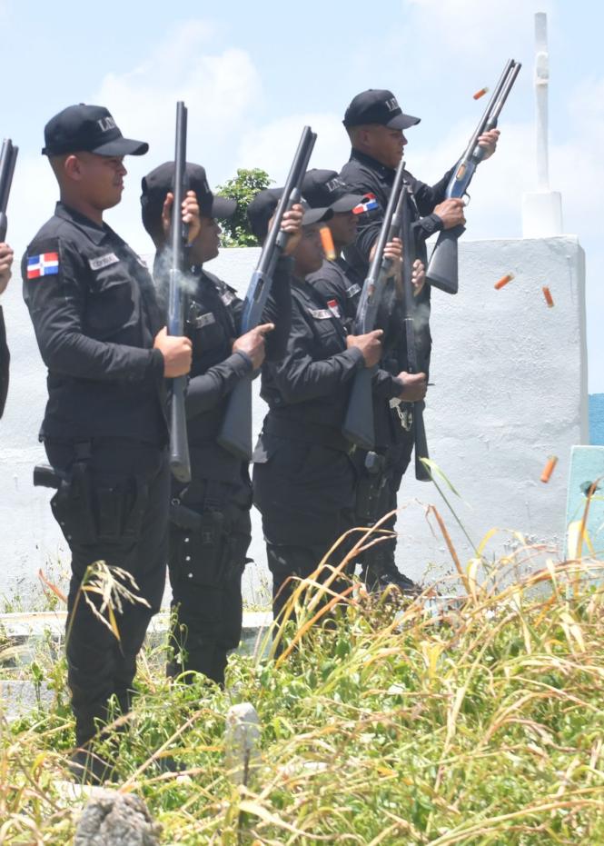 Oficiales mientras recargan sus armas para continuar rindiendo homenaje a su camarada