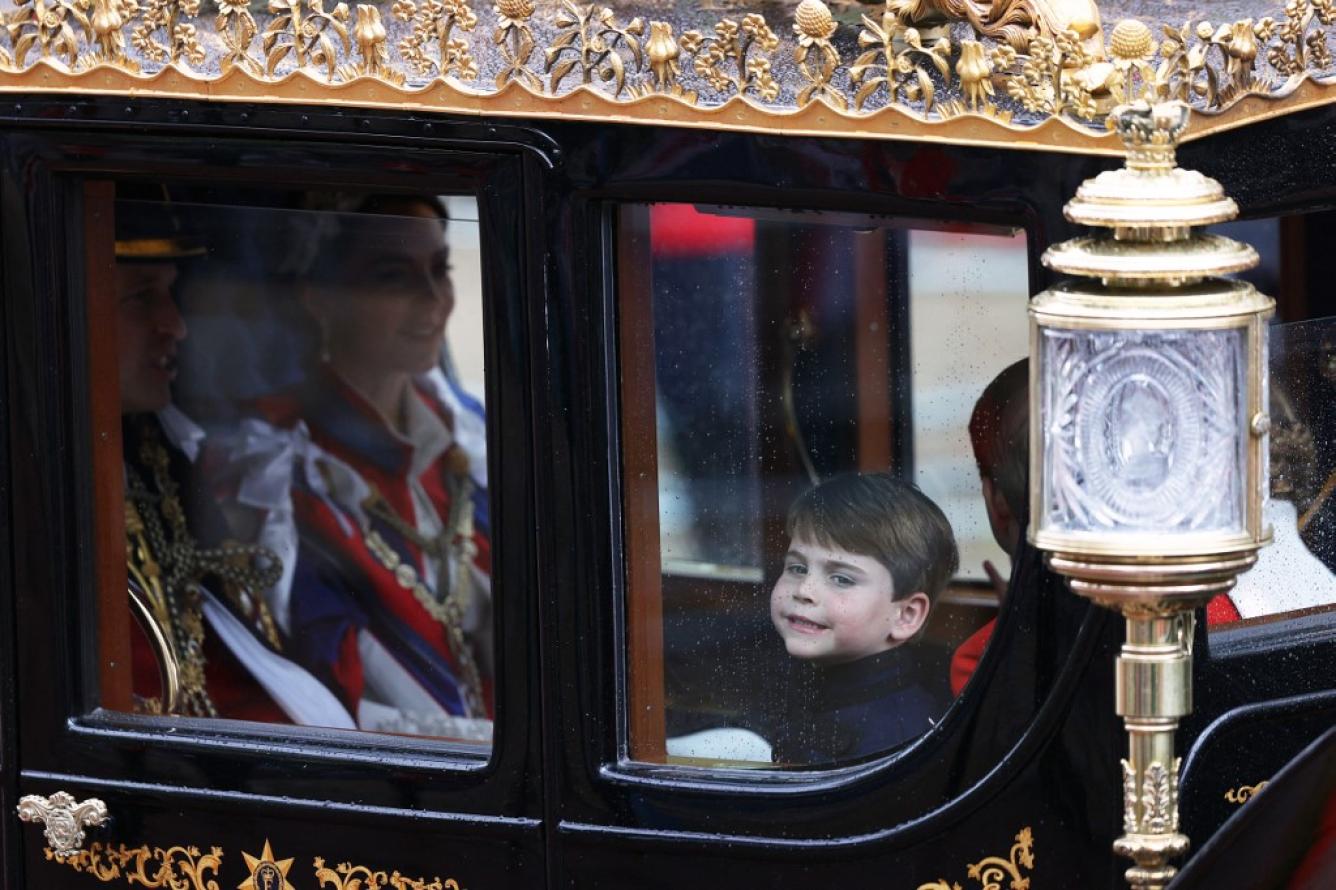 El Príncipe Luis de Gales de Gran Bretaña sonríe a través de la ventana mientras viaja con su familia de regreso al Palacio de Buckingham desde la Abadía de Westminster en el centro de Londres el 6 de mayo de 2023, después de las coronaciones del Rey Carlos III de Gran Bretaña y la Reina Camila de Gran Bretaña. La coronación es la primera en Gran Bretaña en 70 años, y solo la segunda en la historia en ser televisada.