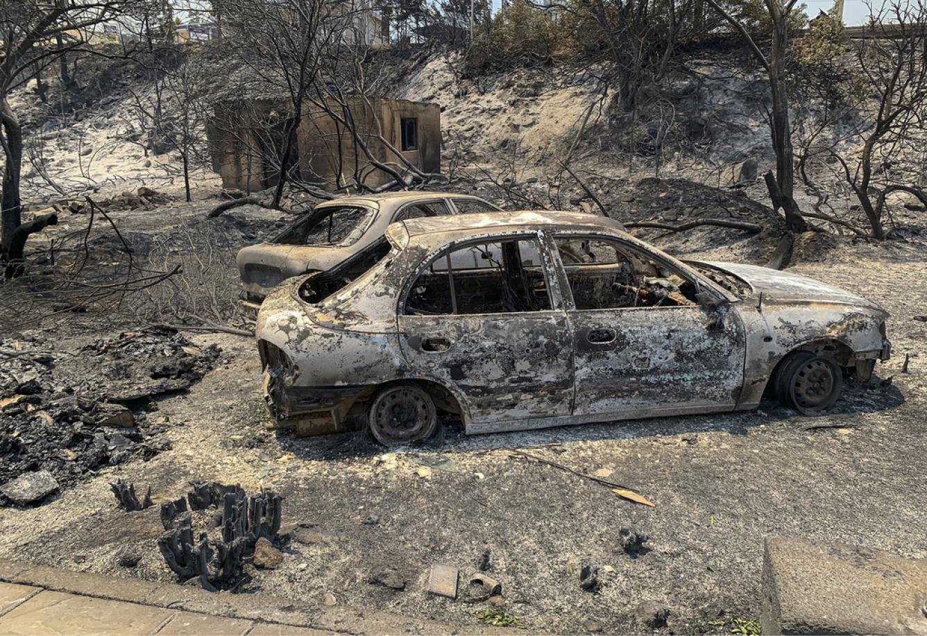 Restos de automóviles quemados en una carretera después de un incendio forestal en la isla de Rodas