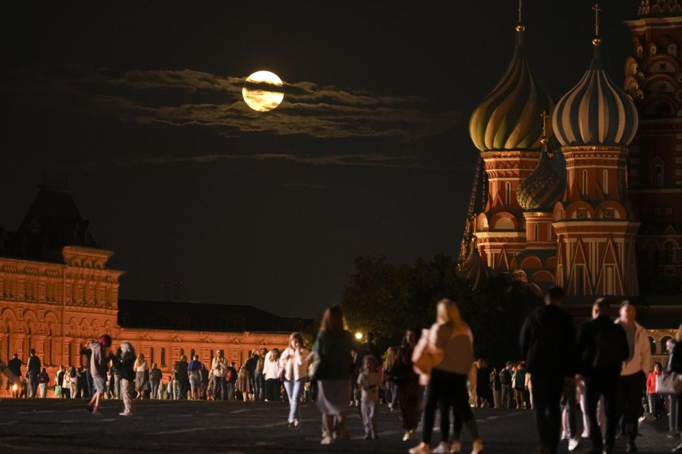 La Super Luna Azul de agosto se ubica detrás de un edificio histórico y la Catedral de San Basilio