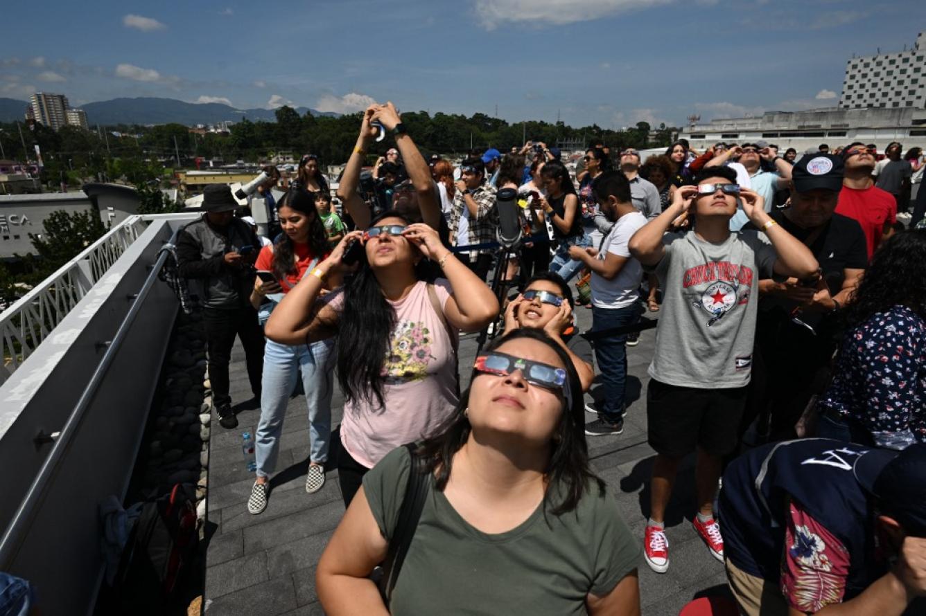 La gente observa el eclipse solar anular en la ciudad de Guatemala el 14 de octubre de 2023. Los observadores del cielo de todo el continente americano volvieron sus rostros hacia arriba el sábado para presenciar un raro evento celeste: un eclipse solar anular. Johan ORDÓNEZ / AFP