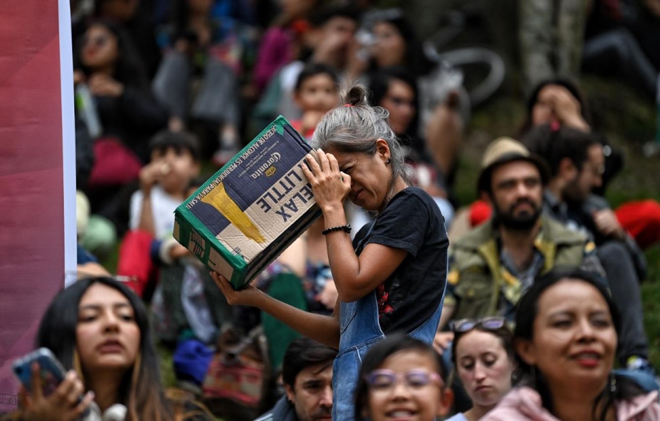 Una mujer utiliza un proyector estenopeico para observar el eclipse solar anular en Bogotá el 14 de octubre de 2023. Los observadores del cielo de todo el continente americano volvieron sus rostros hacia arriba el sábado para presenciar un raro evento celeste: un eclipse solar anular. JUAN BARRETO/AFP