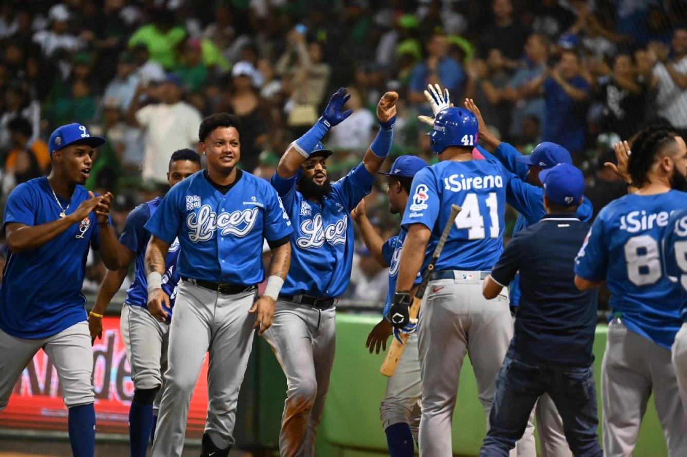 Emilio Bonifacio es felicitado por sus compañeros tras anotar una de las carreras de los Tigres del Licey.