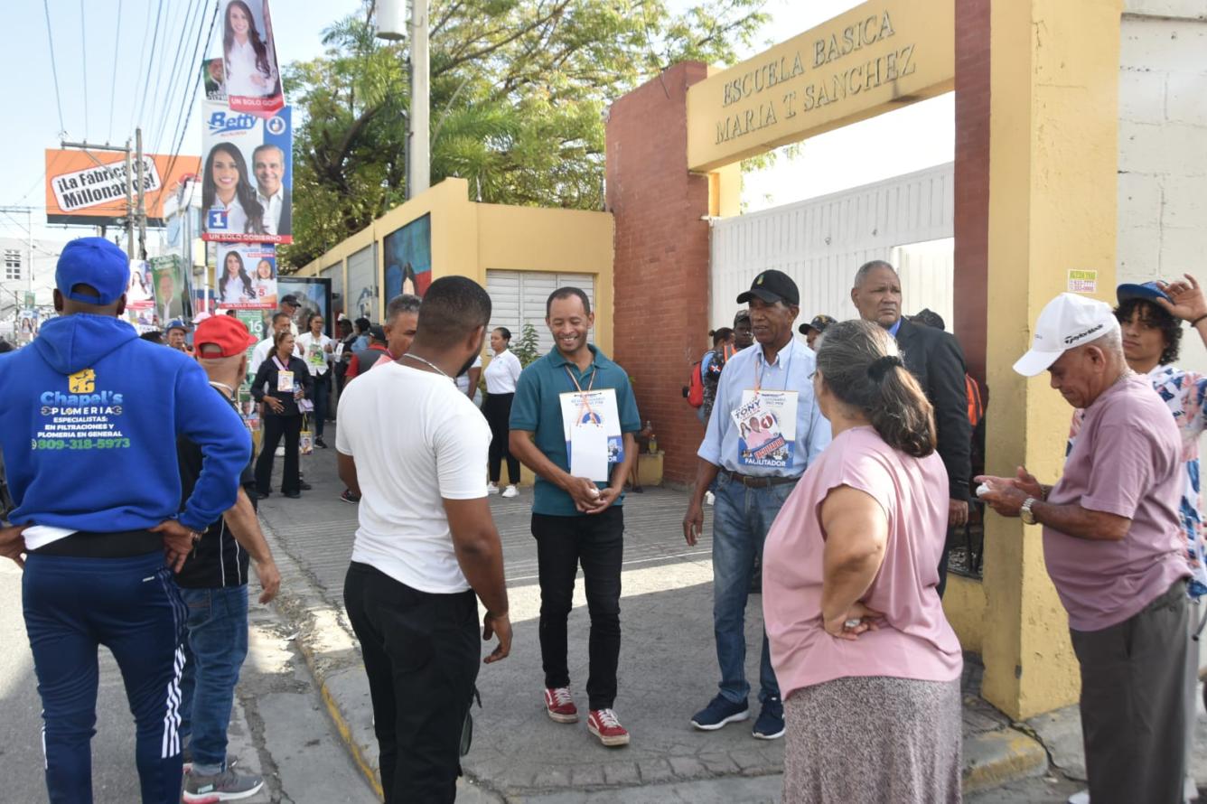 En el colegio electoral de la Escuela Básica María Trinidad Sánchez, decenas de personas esperan afuera para poder ingresar al recinto.