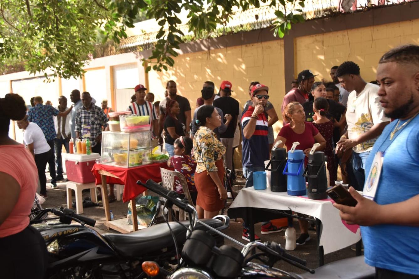 Varias personas en una larga fila en las afueras de este colegio electoral, para votar.