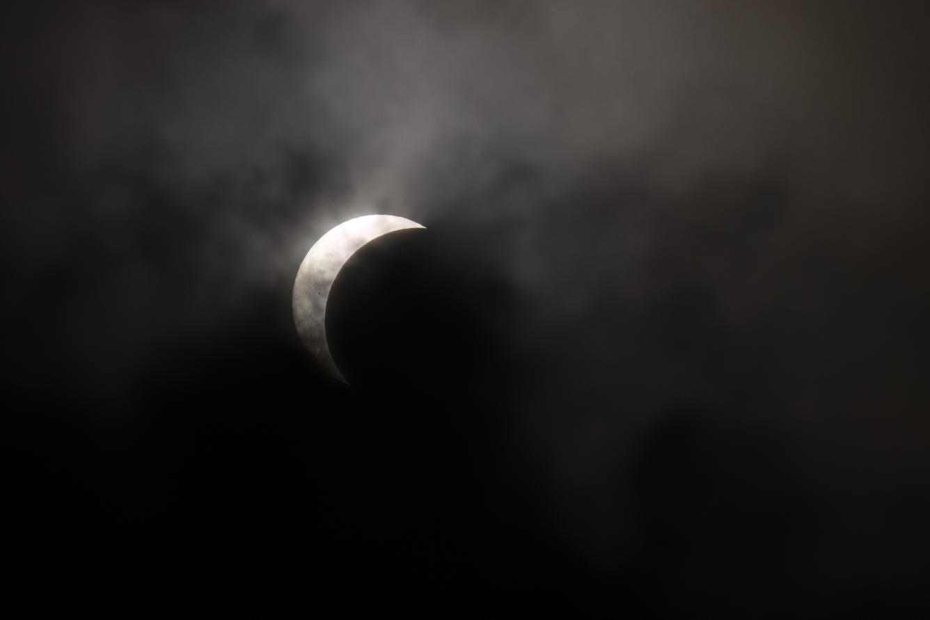 A view of the partial solar eclipse as it recedes behind the clouds as seen from Austin, Texas on April 8, 2024. This year's path of totality is 115 miles (185 kilometers) wide and home to nearly 32 million Americans, with an additional 150 million living less than 200 miles from the strip. The next total solar eclipse that can be seen from a large part of North America won't come around until 2044. (Photo by SUZANNE CORDEIRO / AFP)