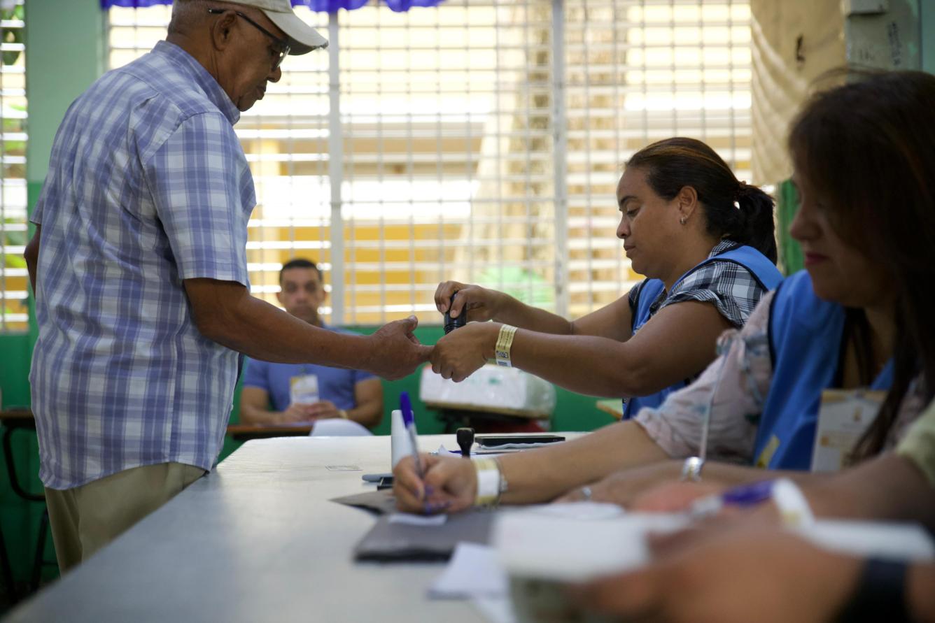 Fotografía muestra a elector que finalizó su votación y se le coloca tintado en su dedo índice.