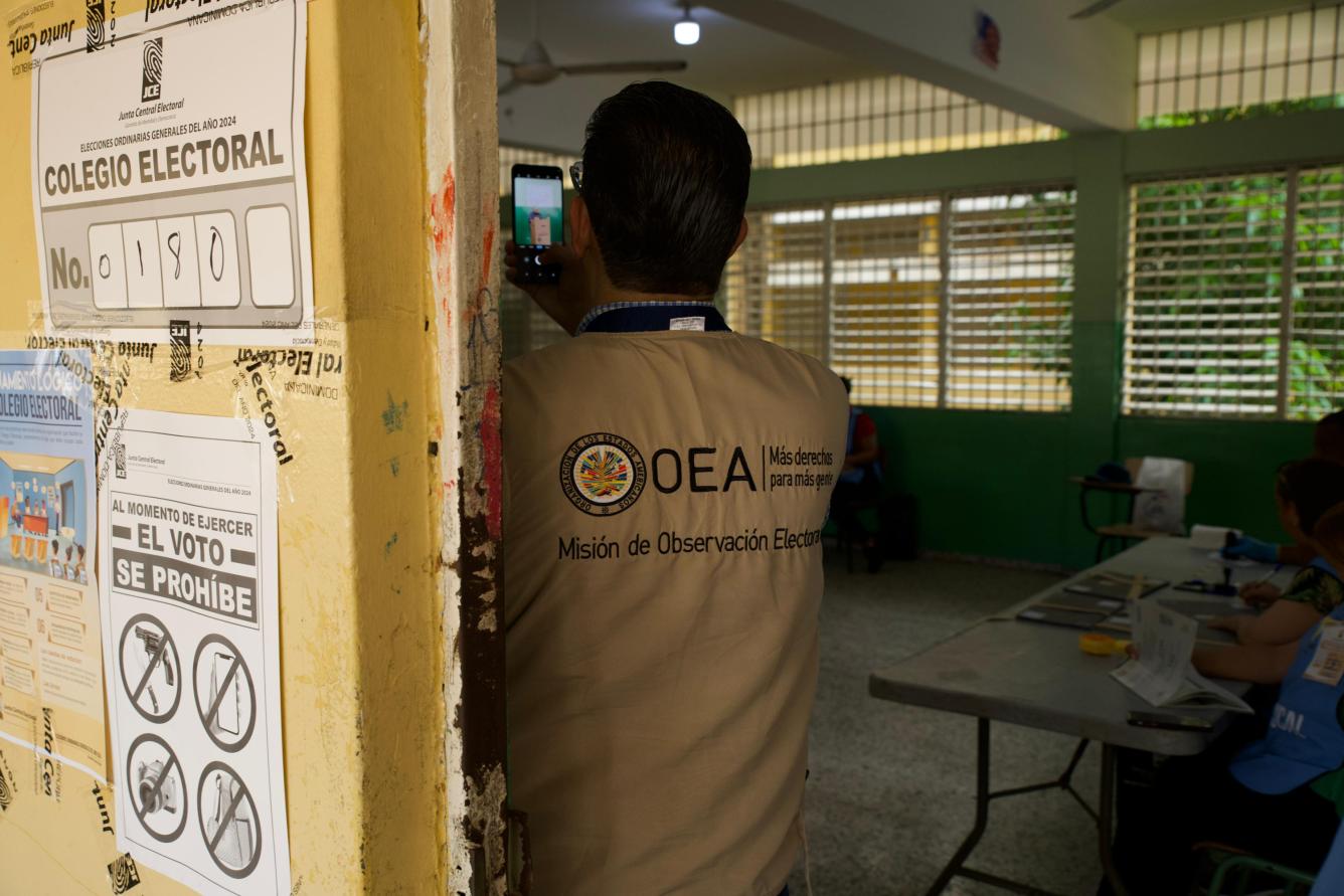 Fotografía muestra a observador de la OEA en el proceso de votación de un elector.