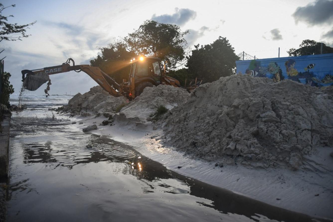Personal del Ministerio de Transporte, Obras e Infraestructura limpia arena del desagüe después del paso del huracán Beryl en los jardines de Oistins, Christ Church, Barbados, el 1 de julio de 2024.