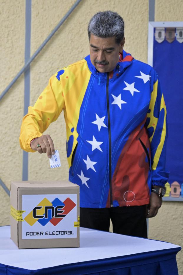 Venezuelan opposition presidential candidate Edmundo Gonzalez Urrutia shows his ballot as he votes at the Santo Tomas de Villanueva school in Caracas during the presidential election on July 28, 2024. Venezuelans vote Sunday between continuity in President Nicolas Maduro or change in rival Edmundo Gonzalez Urrutia amid high tension following the incumbent's threat of a 