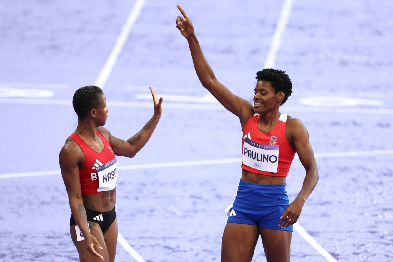 Dominican Republic's Marileidy Paulino celebrates next to Bahrain's Salwa Eid Naser after winning the women's 400m final of the athletics event at the Paris 2024 Olympic Games at Stade de France in Saint-Denis, north of Paris, on August 9, 2024. (Photo by Anne-Christine POUJOULAT / AFP)