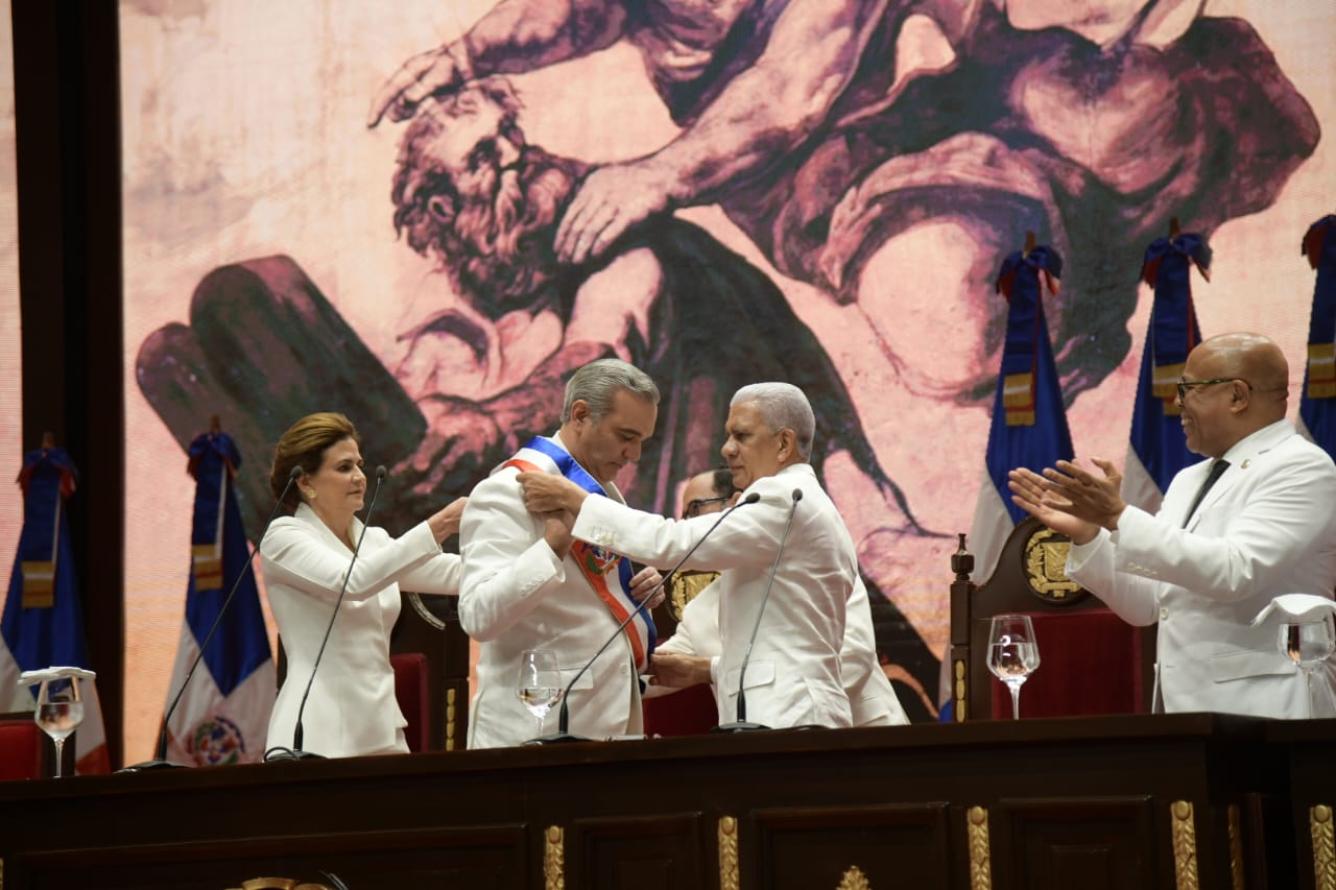 El presidente del Senado, Ricardo de los Santos, coloca la banda presidencial a Luis Abinader.