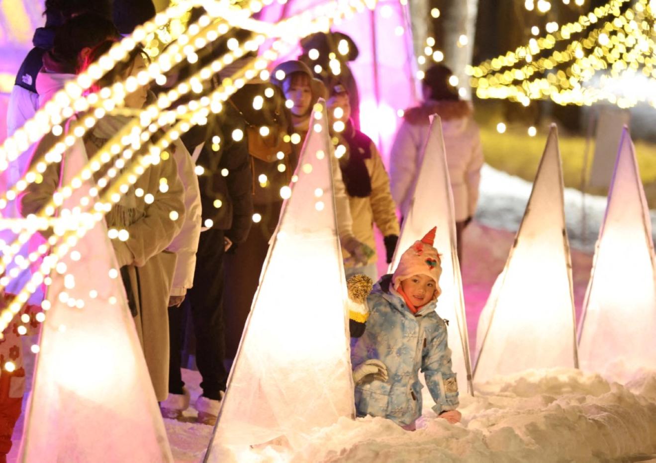 Visitantes disfrutando la iluminación en el Furano Kan Kan Mura, en Japón.