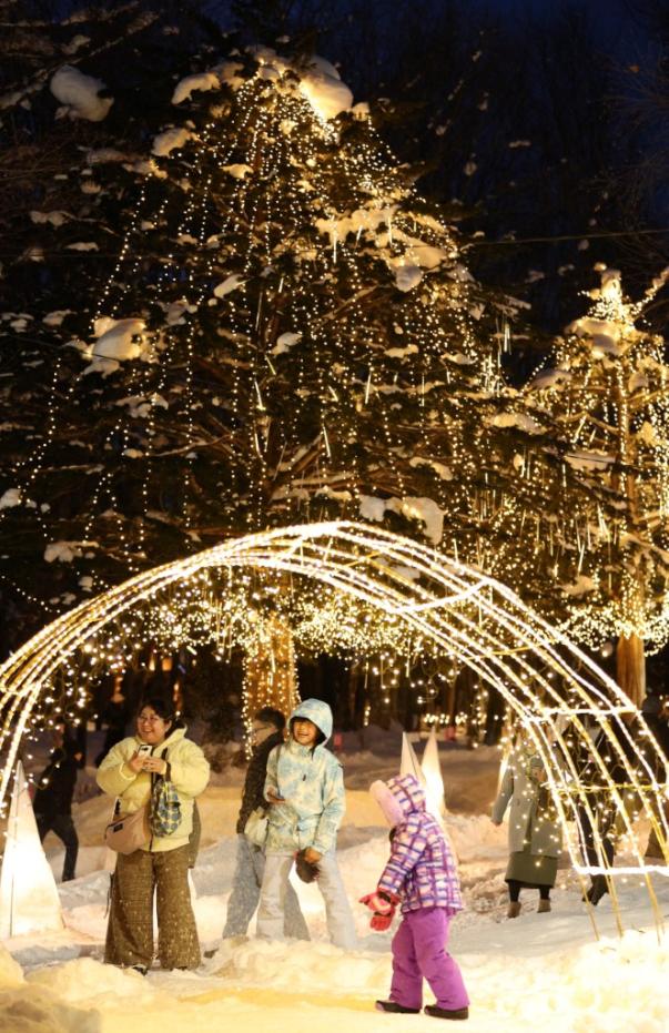 Visitantes disfrutando la iluminación del Furano Kan Kan Mura, en la ciudad de Murano en Japón.