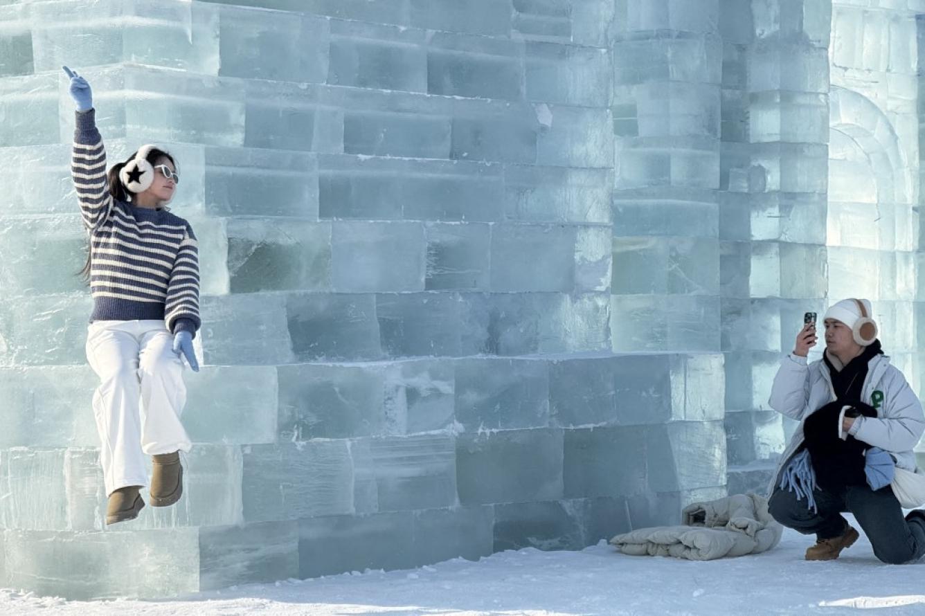 Una turista posa en el festival de esculturas de hielo y nieve de Harbin en China