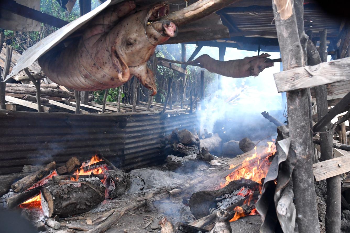 Comerciantes asan cerdo para su comercialización en Nochebuena