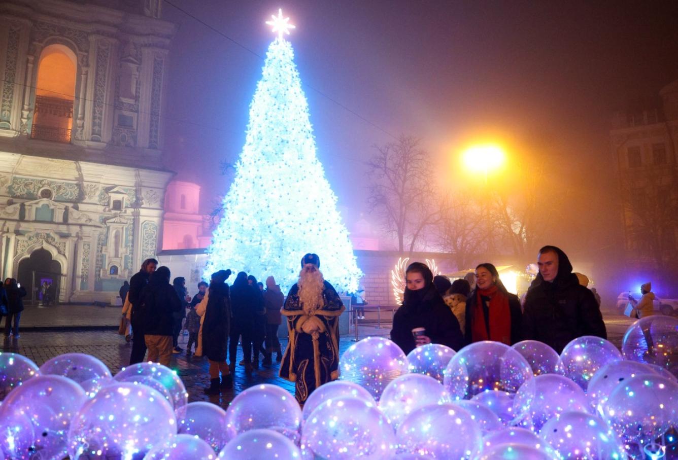 Los residentes locales se encuentran cerca del árbol de Navidad en la Plaza Sofía en Kiev, el 24 de diciembre de 2024, en medio de la invasión rusa en Ucrania.