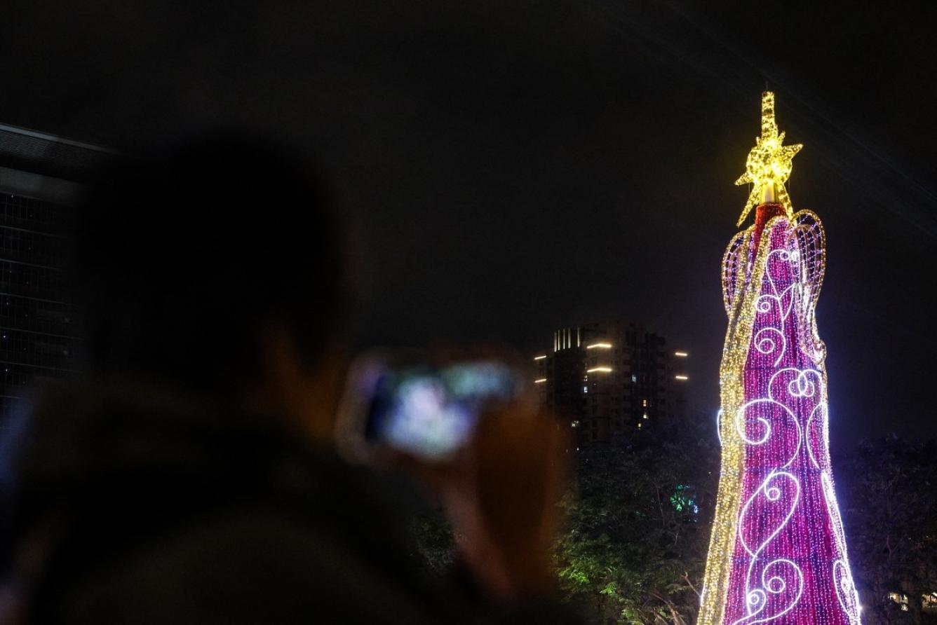 Un visitante toma fotografías de un árbol de Navidad durante el New Taipei Christmasland 2024 en la víspera de Navidad en la ciudad de New Taipei el 24 de diciembre de 2024.