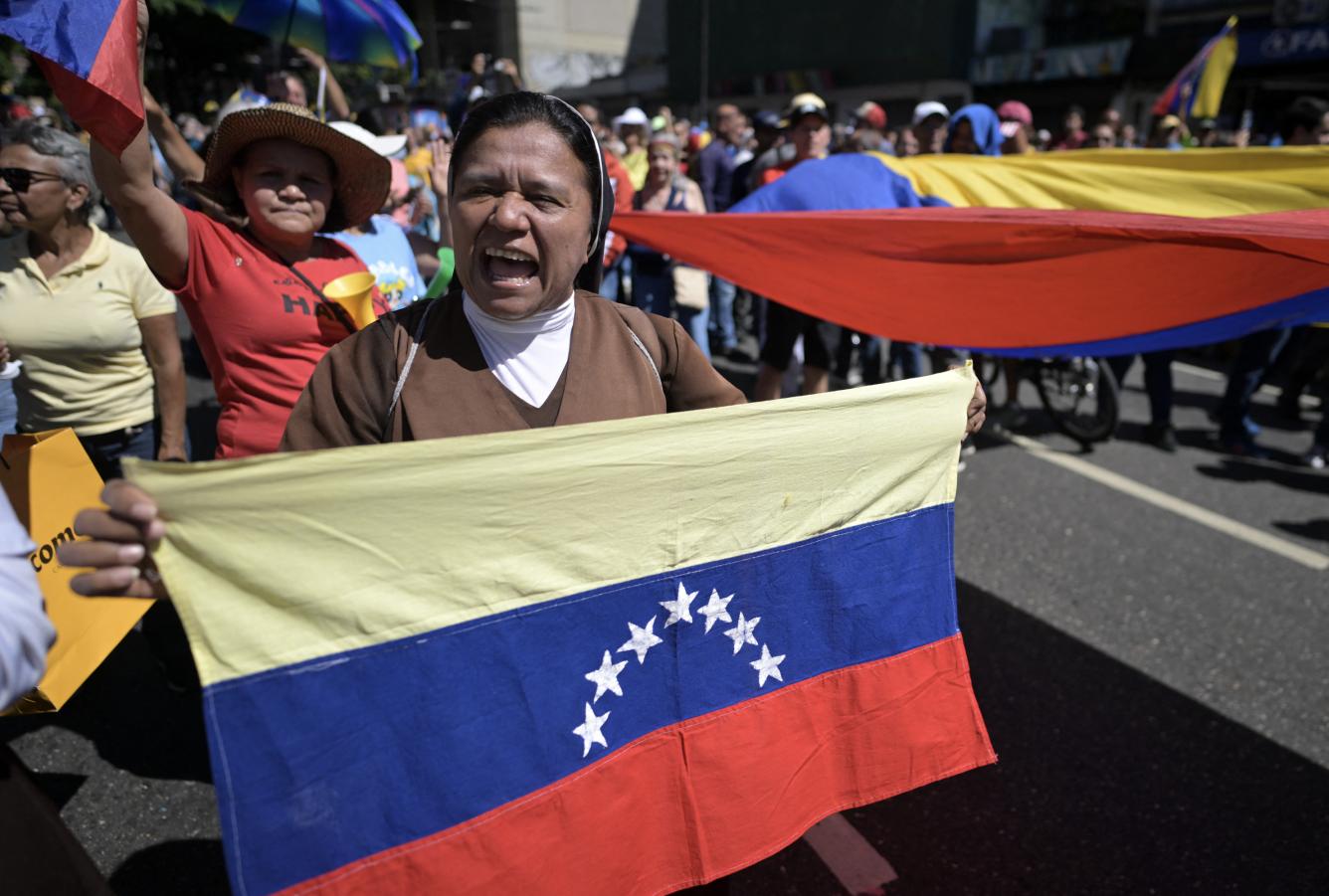 Una monja con una bandera venezolana grita consignas