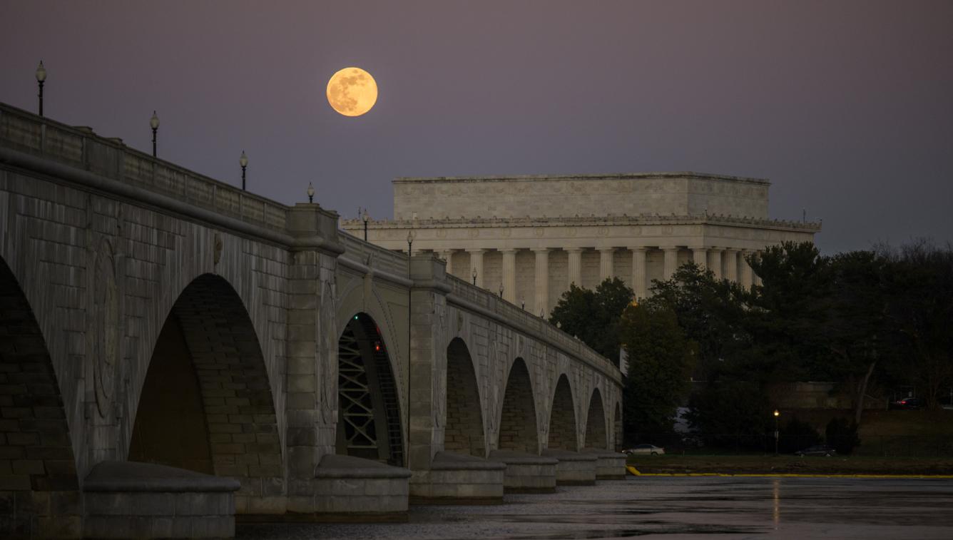 Luna llena se eleva detrás del Monumento a Lincoln y el Puente Memorial