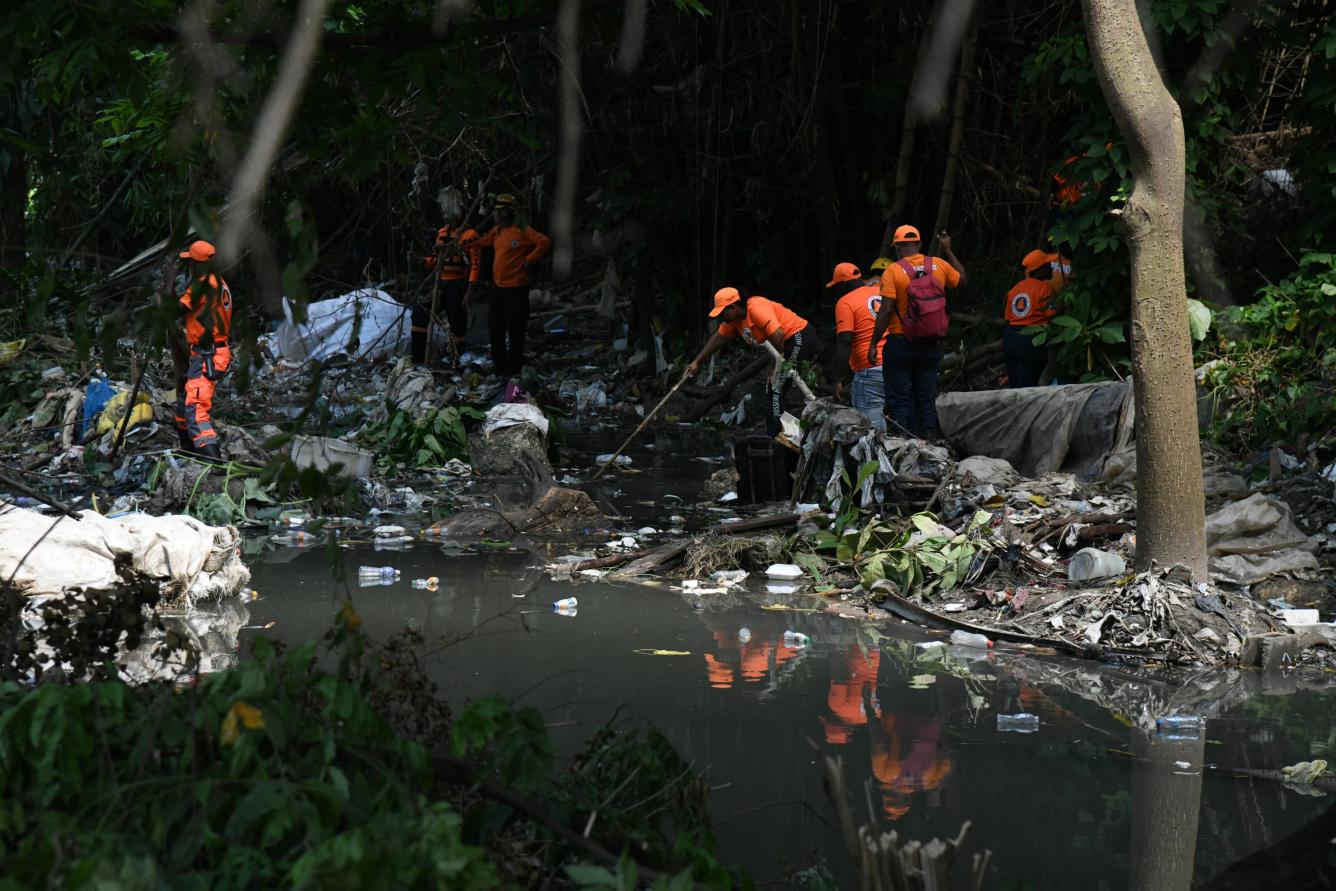 Miembros de la Defensa Civil realizan búsqueda en aguas negras de la cañada donde desapareció Yuleili Serrano el jueves 5 de junio.