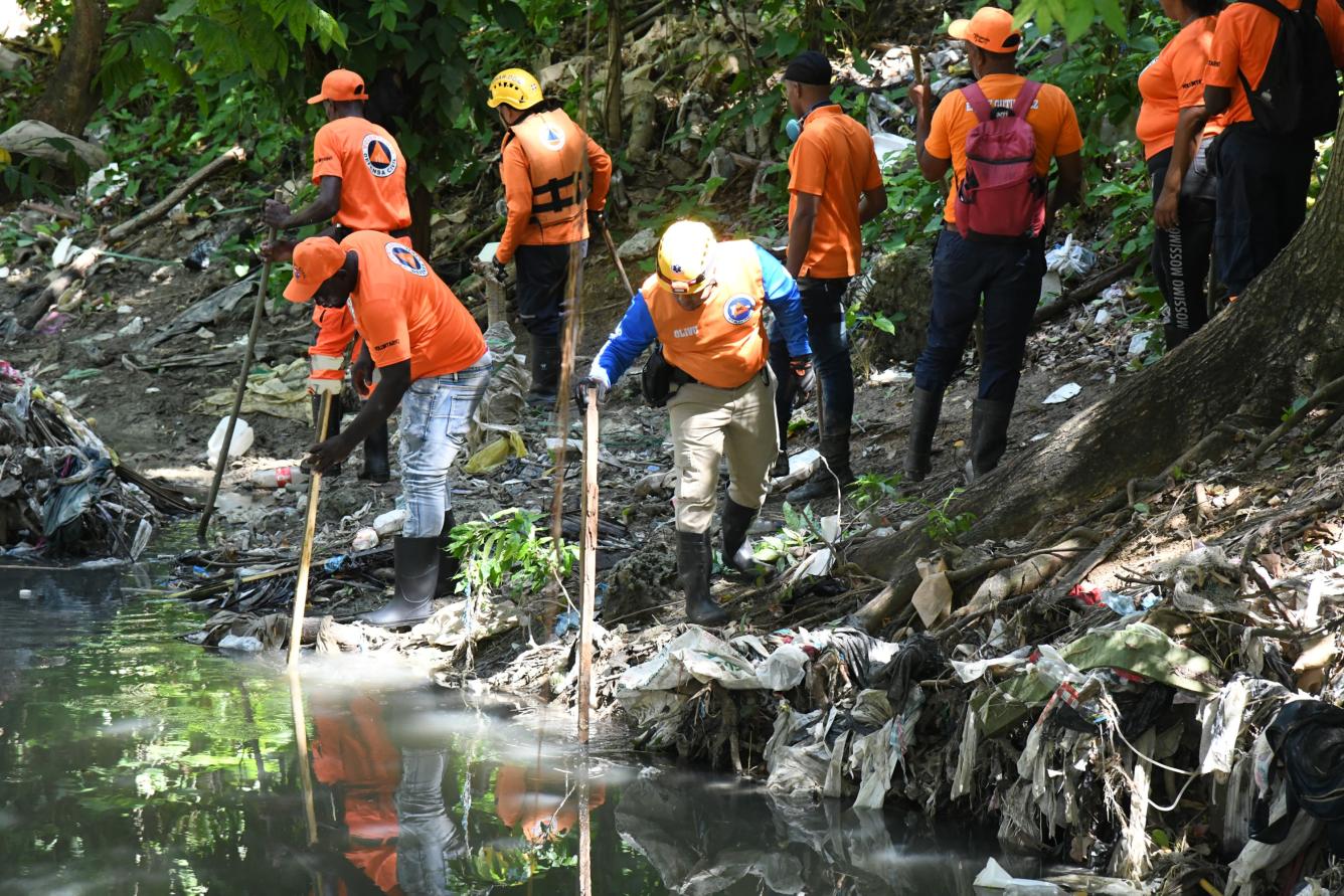 Miembros de la Defensa Civil realizan búsqueda en aguas negras de la cañada donde desapareció Yuleili Serrano el jueves 5 de junio.