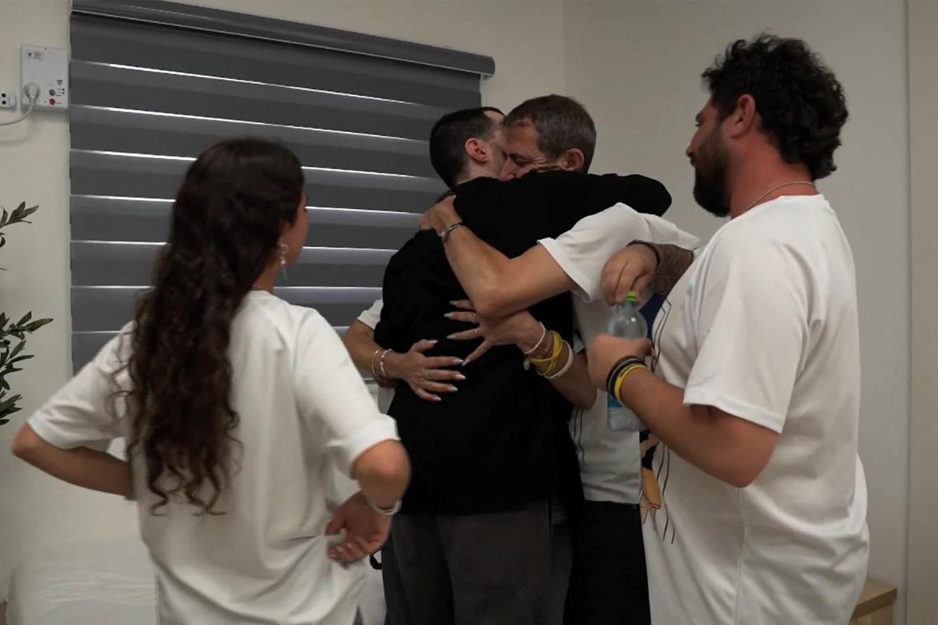 Esta fotografía, difundida por el ejército israelí, muestra al rehén israelí liberado Guy Gilboa-Dalal (vestido de negro), uno de los ex cautivos en Gaza desde los ataques del 7 de octubre de 2023 perpetrados por militantes palestinos, siendo abrazado por un familiar tras ser entregado en un intercambio de prisioneros y rehenes, en el marco de un acuerdo de alto el fuego entre Israel y Hamás en Israel el 13 de octubre de 2025.